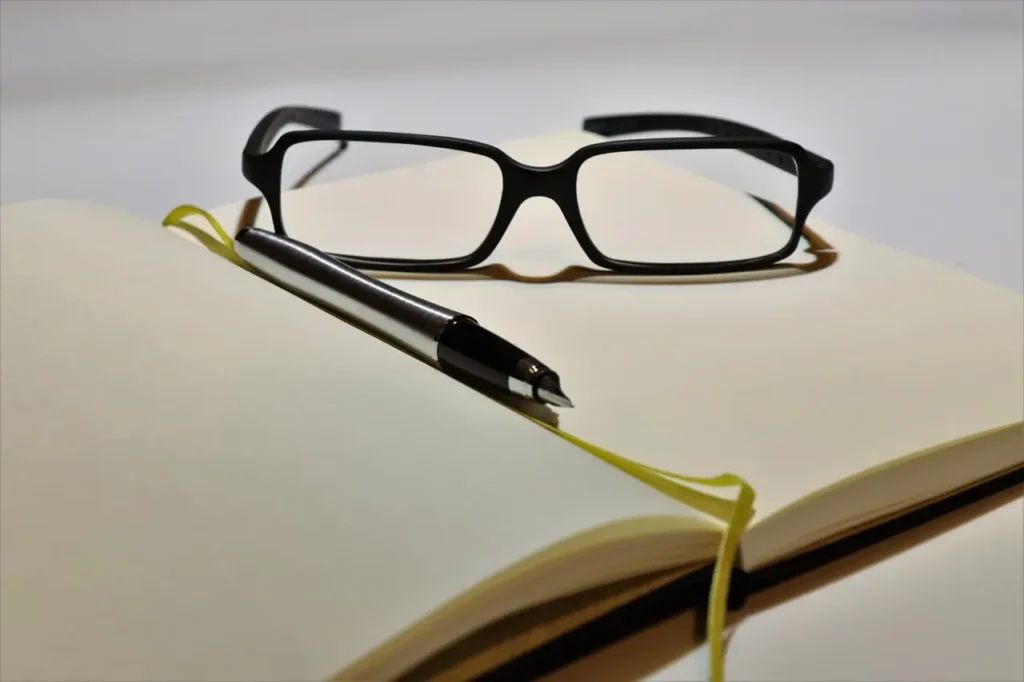 Notebook and glasses on a desk, symbolizing preparation for polygraph testing